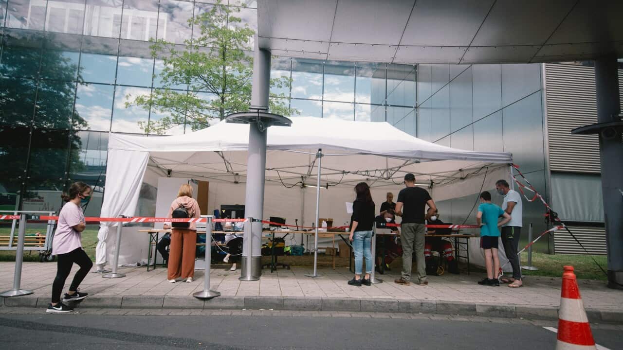 People queue up for coronavirus testing in Cologne, Germany