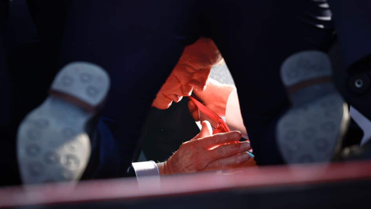 A view of a bleeding man through another man's legs