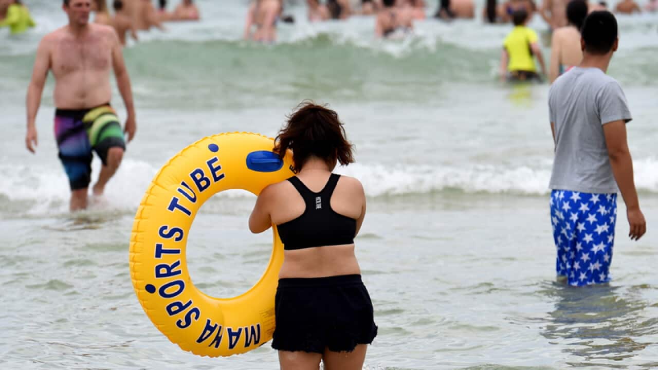 People gather in the water at Bondi Beach