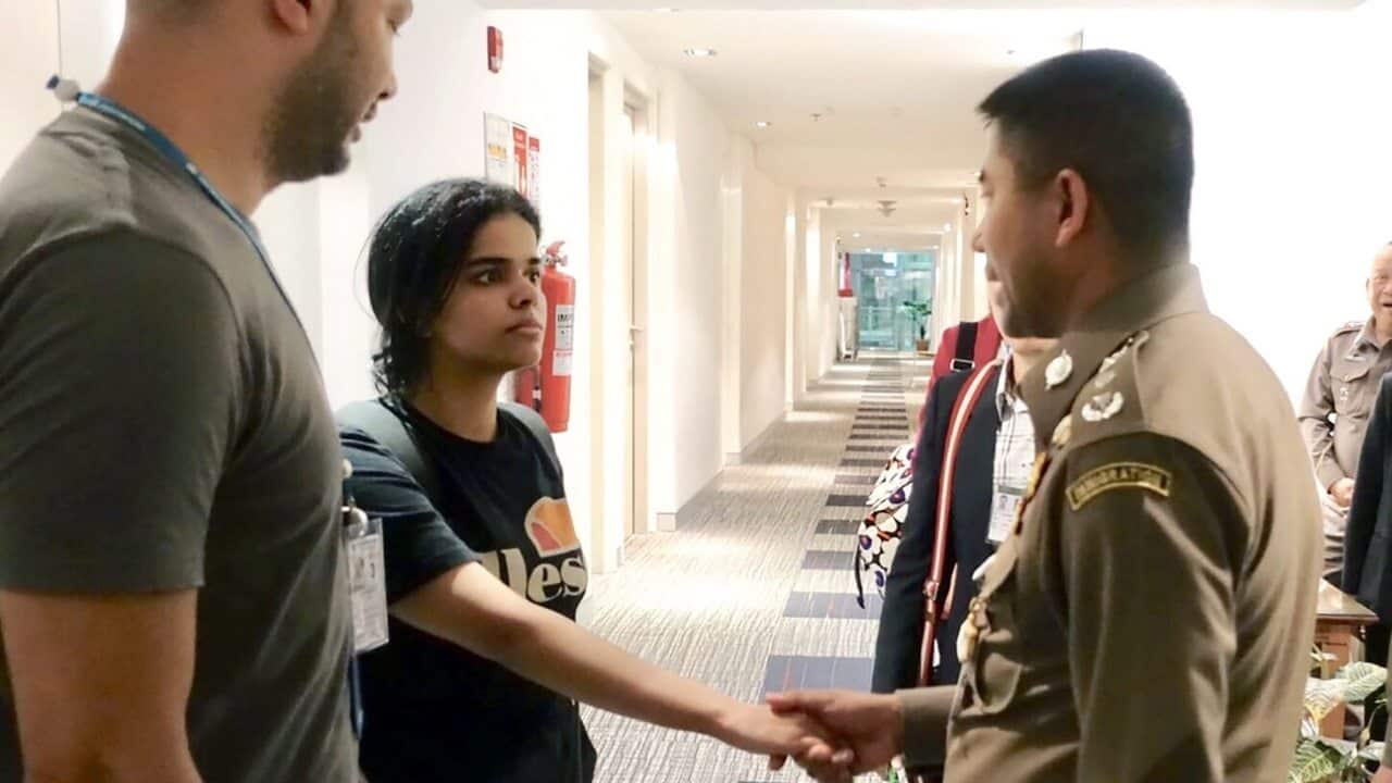 Rahaf Mohammed al-Qunun shakes hands with Thai Immigration Police Chief Surachet Hakparn.