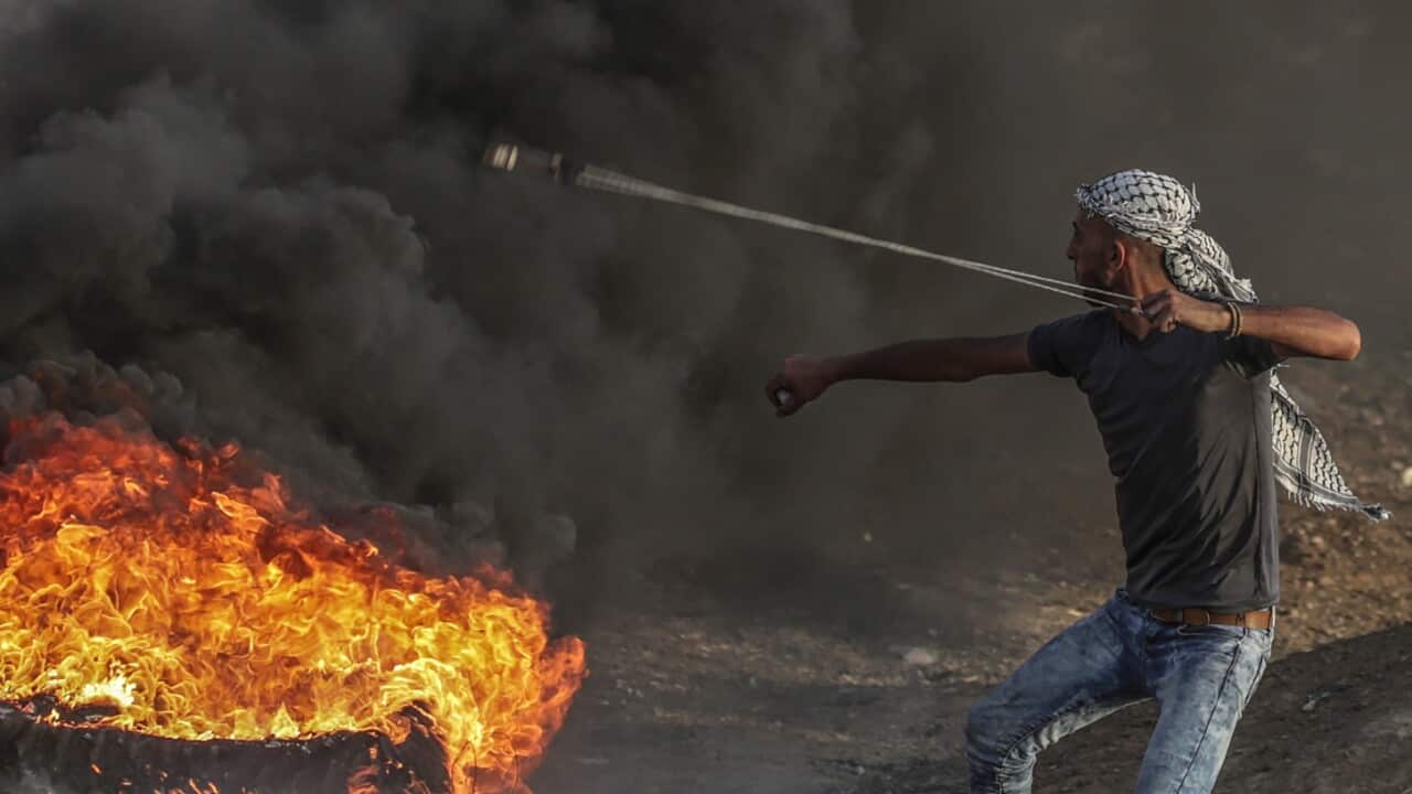 A Palestinian protester throw stones during the clashes near the border between Israel and Gaza Strip, eastern Gaza City on, 18 May 2018. 