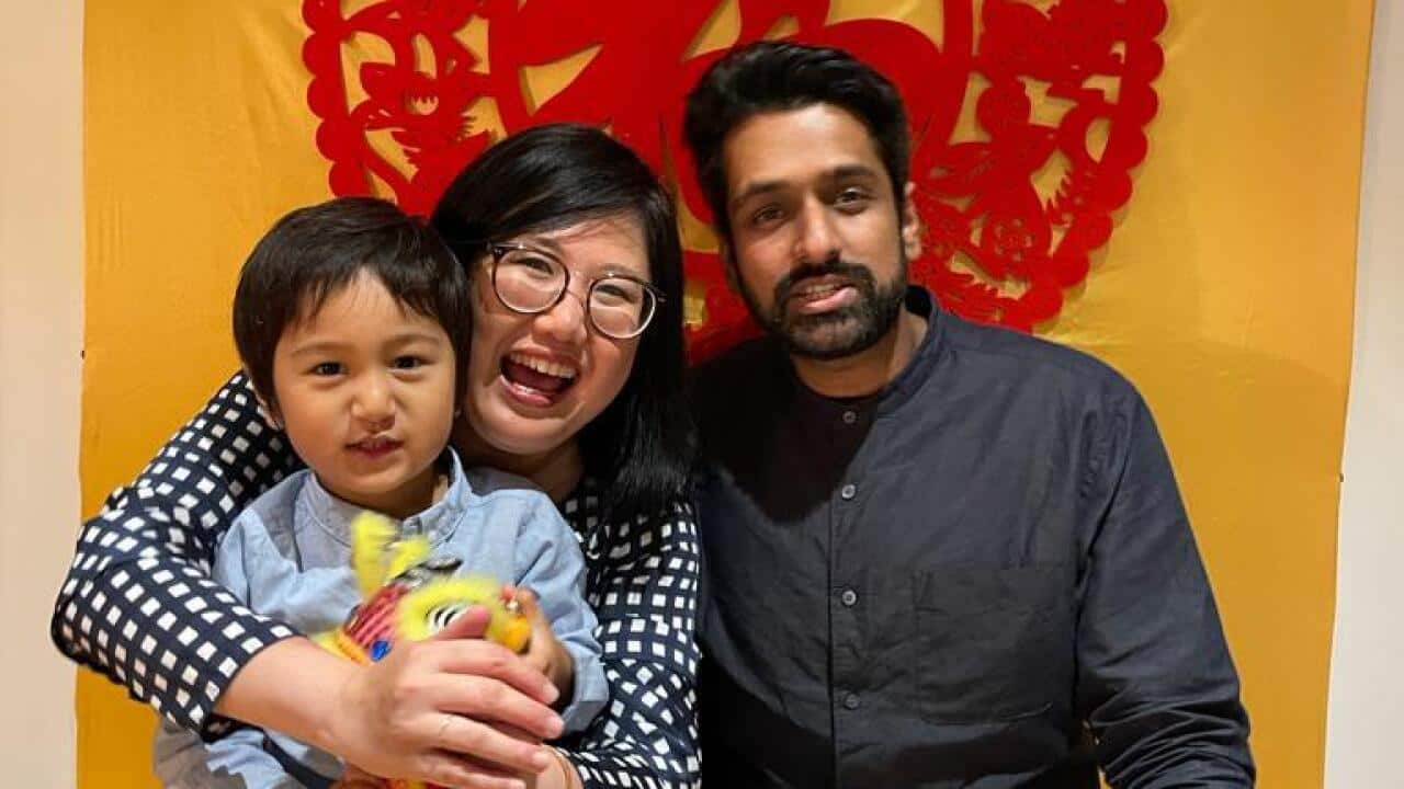 picture of a man, a woman and a child sitting and smiling