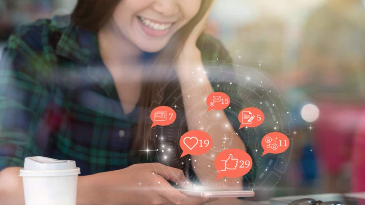 Social media concept, Asian woman hand using mobile phone to check social network application with number of Like, Love, comment, people and fovorite icon at desk beside glass in coffee shop