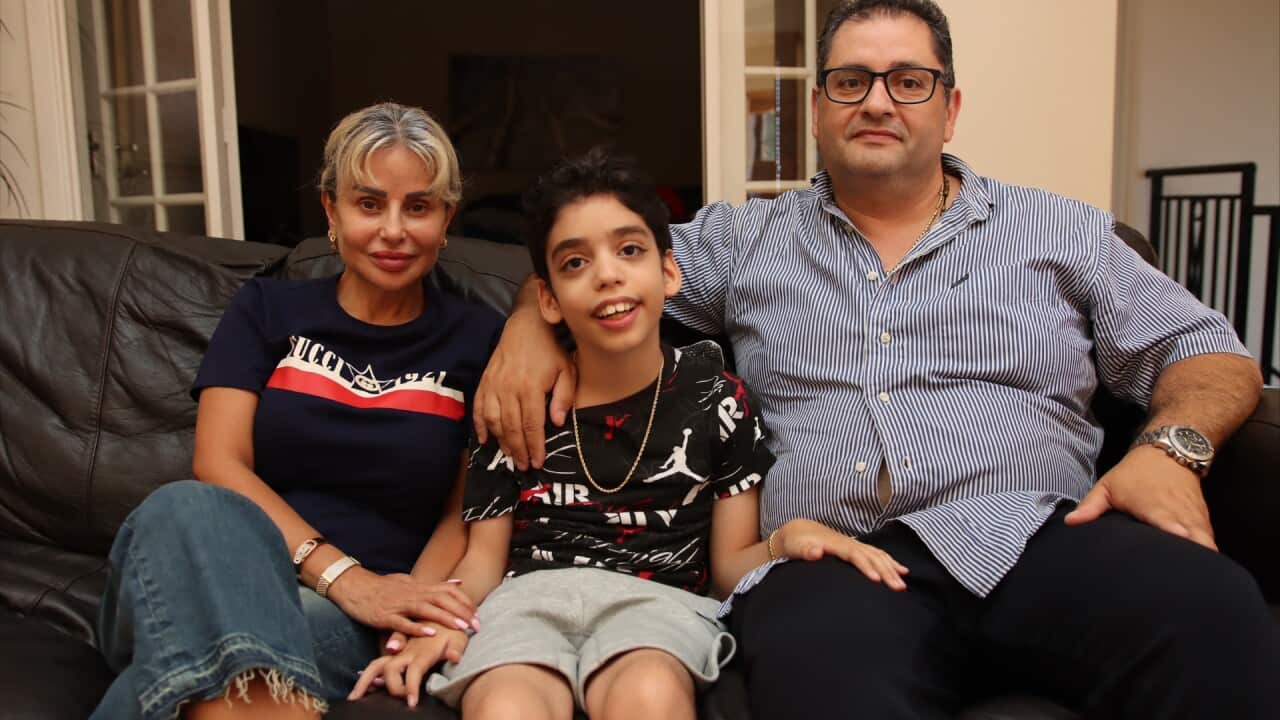 Alicio Haddad (centre) is pictured with his dad, Pierre, and his mum. They are sitting next to each other on the couch.