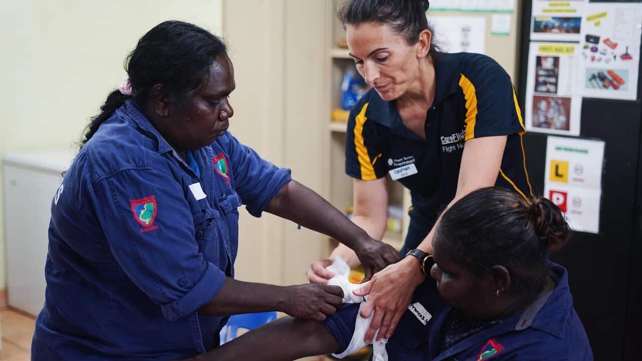 Care Flight nurse Jayne Sheppard (centre) teaches Thamarrurr Rangers how to tourniquet (SBS)
