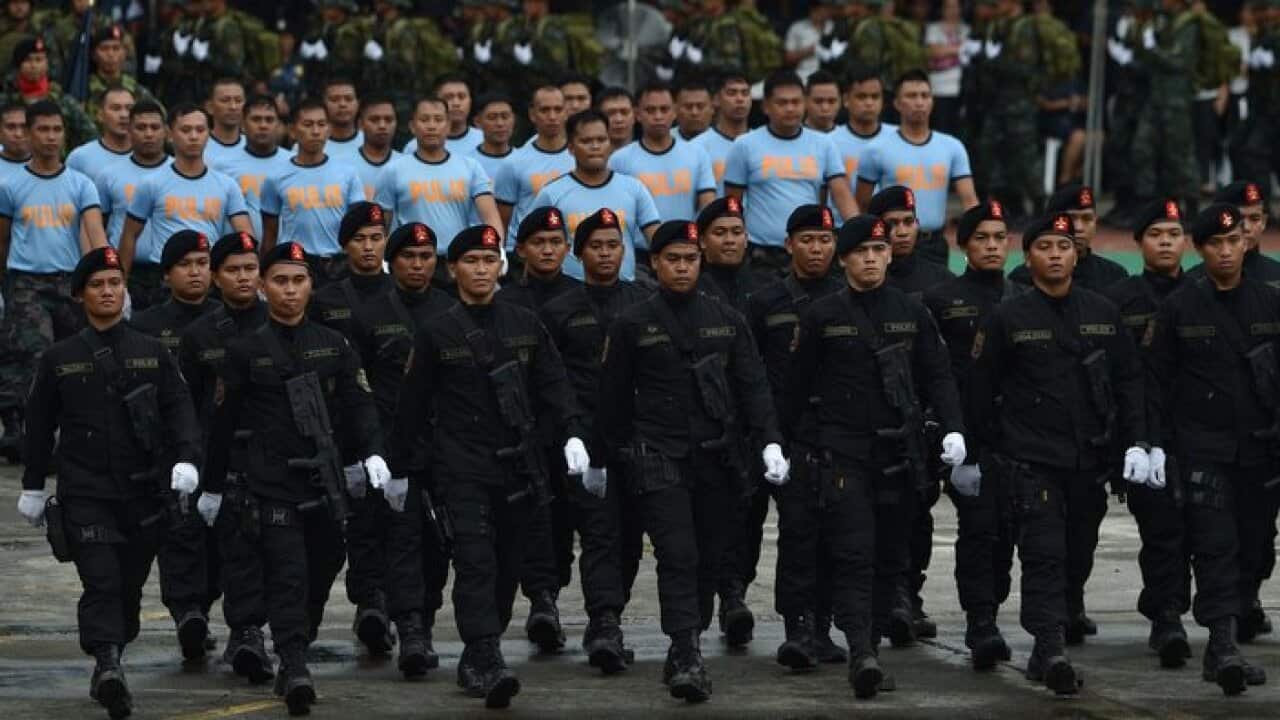 Policemen march in a review of troops during the 117th police anniversary celebration at the national headquarters in Manila