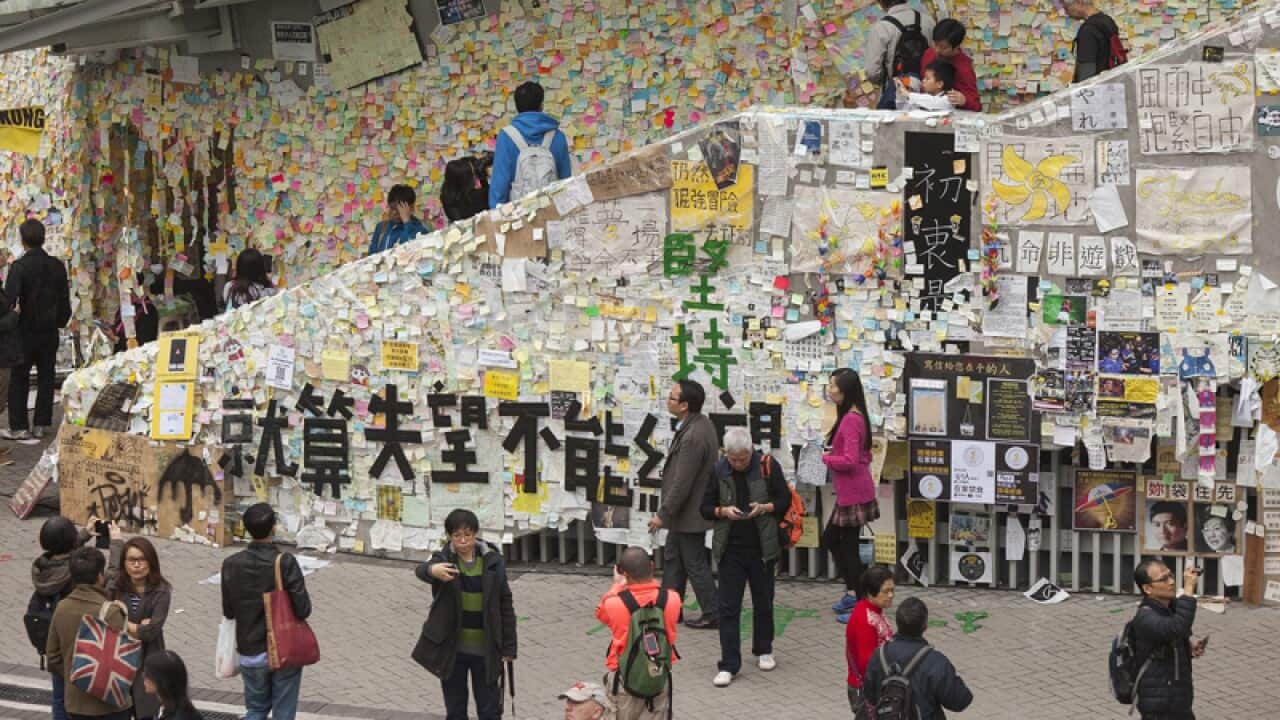 People take photos of the Lennon Wall at the Admiralty camp
