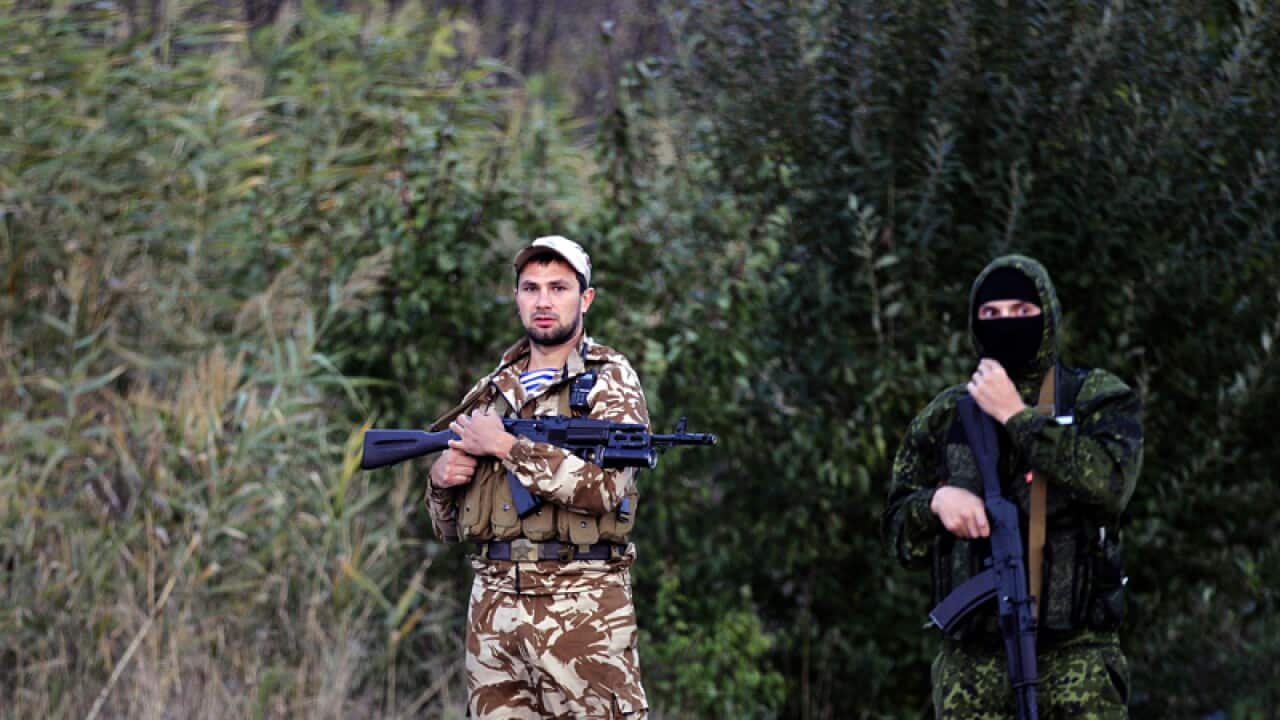 Pro-Russian rebels guard the road during prisoner exchange, Ukraine.