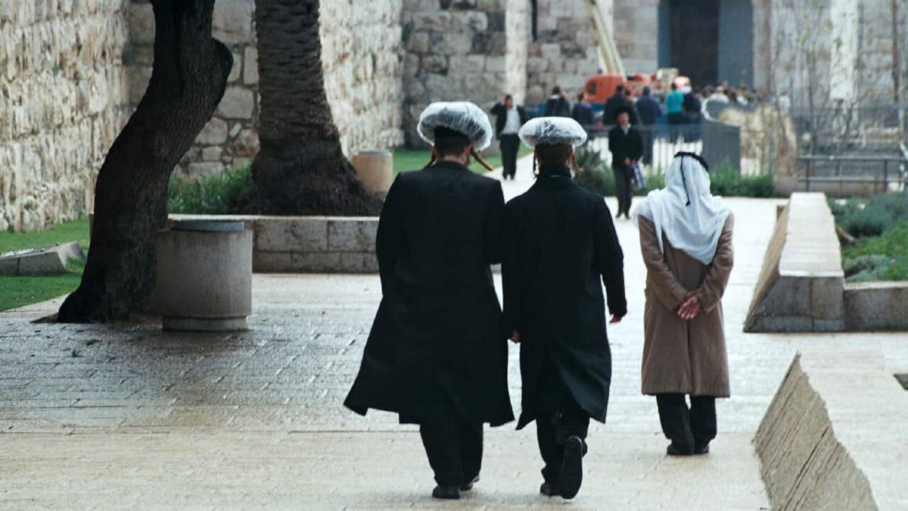 Haredi ultra-orthodox Jews walking by the old city walls in Jerusalem