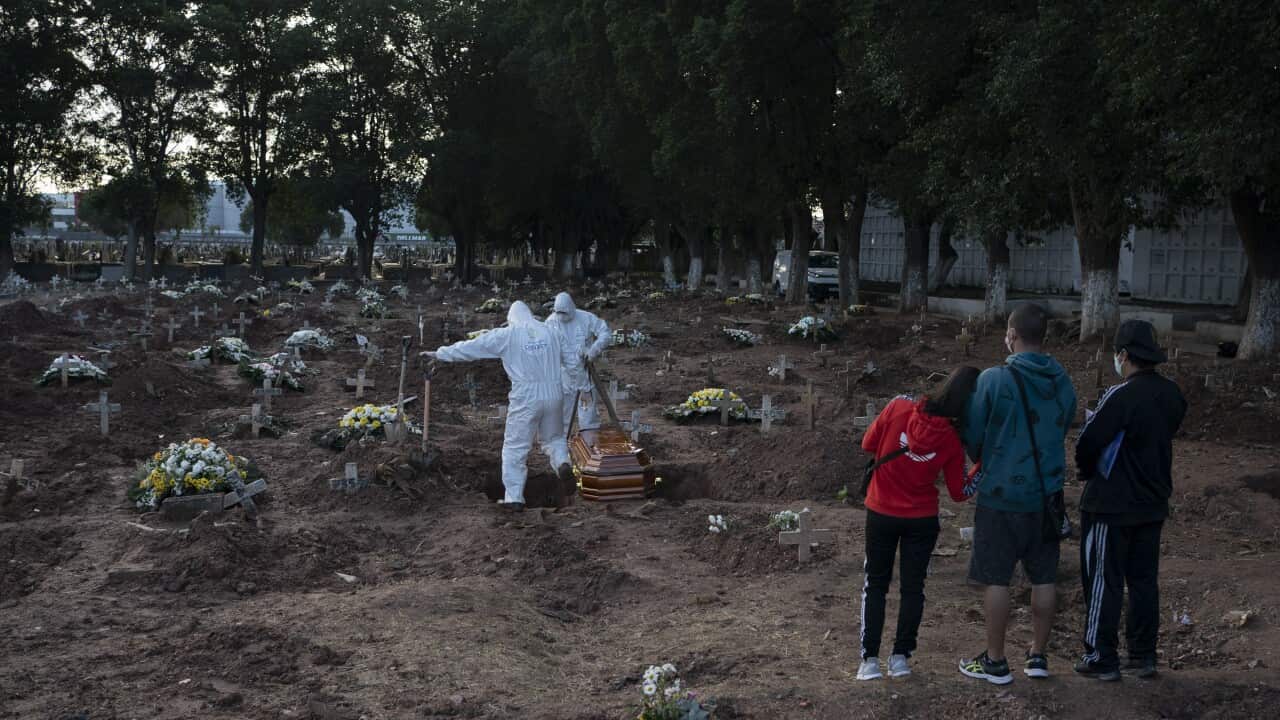 Relatives attend the burial of 71-year-old Neide Rodrigues Rosa, who died from the new coronavirus according to her son Sergio Rodrigues, in Rio de Janeiro, Brazil, Friday, May 8, 2020. (AP Photo/Leo Correa)