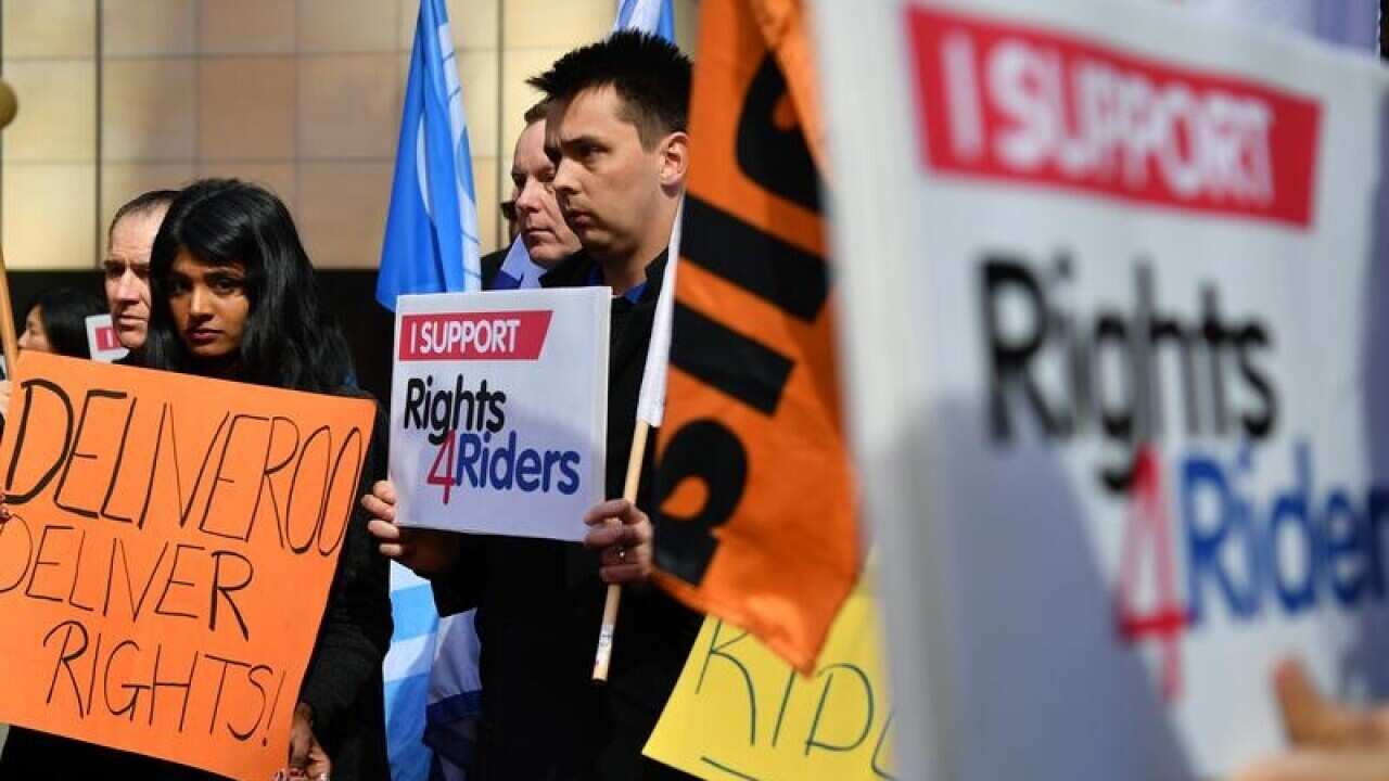 Protesters hold placards during a delivery drivers rally ahead