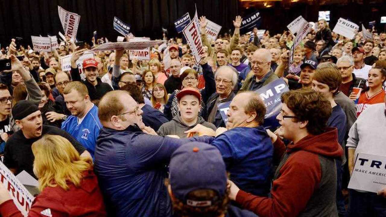 A protester, center left, and a Trump supporter, center right, scuffle during a rally for Republican presidential candidate Donald Trump