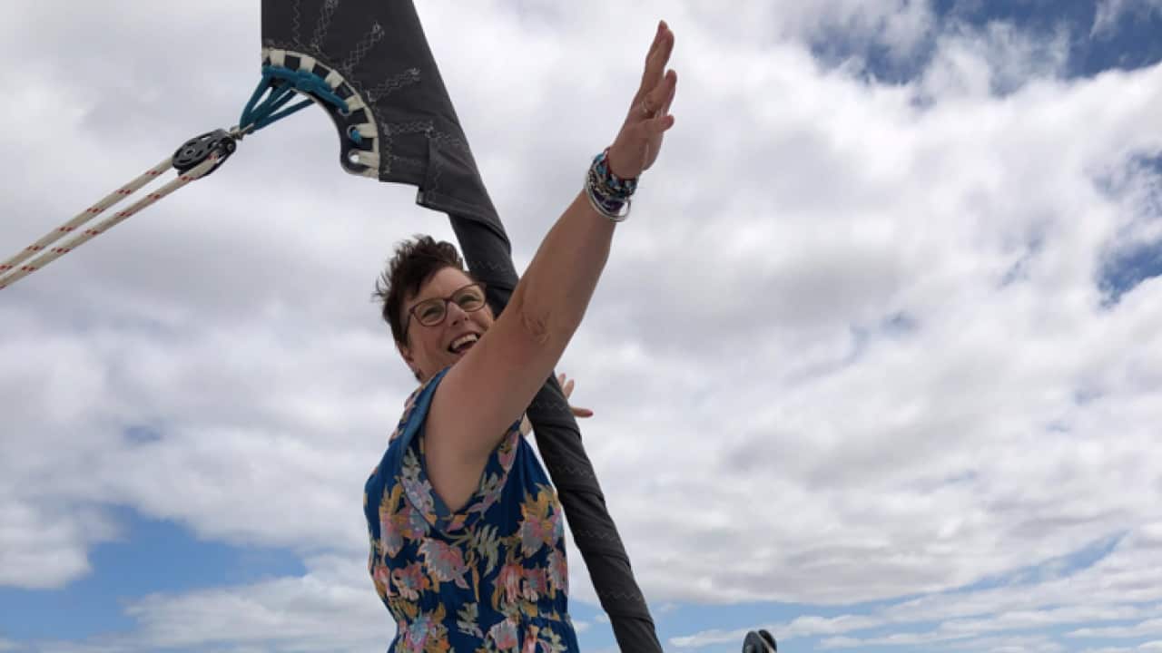 Tash Clark on a boat with her arms up.