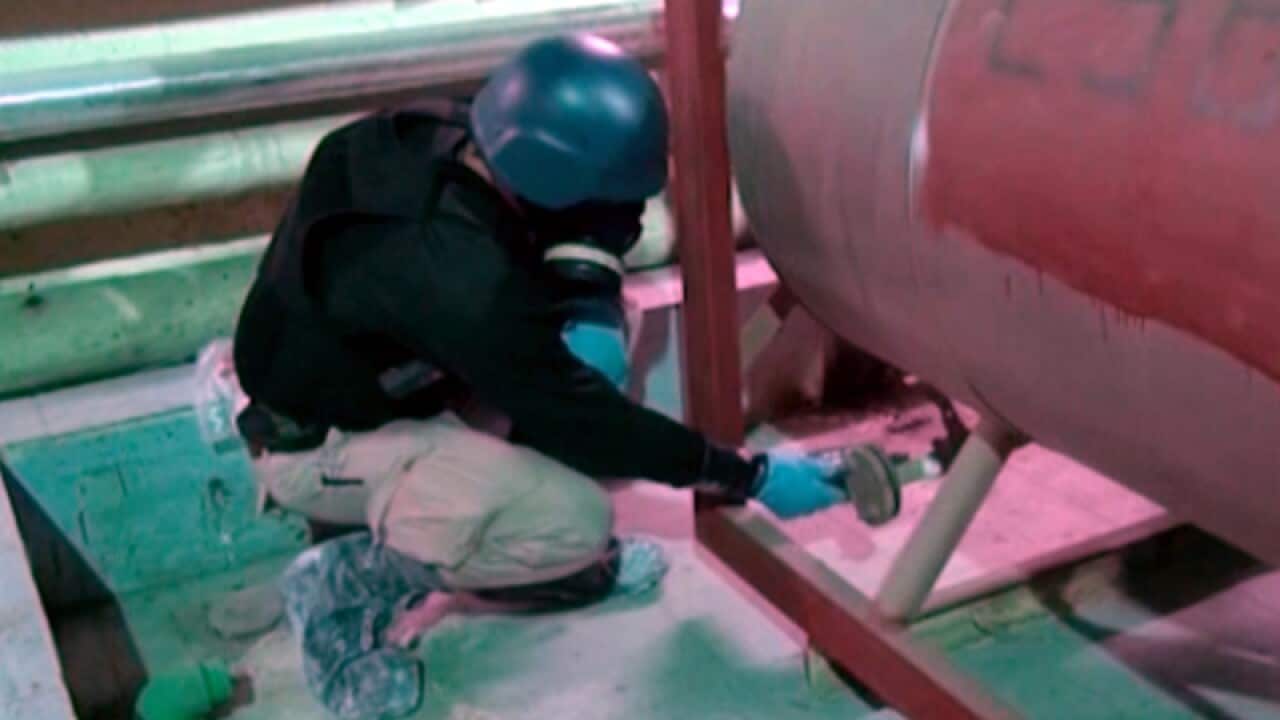 An inspector from the world's chemical watchdog collects samples