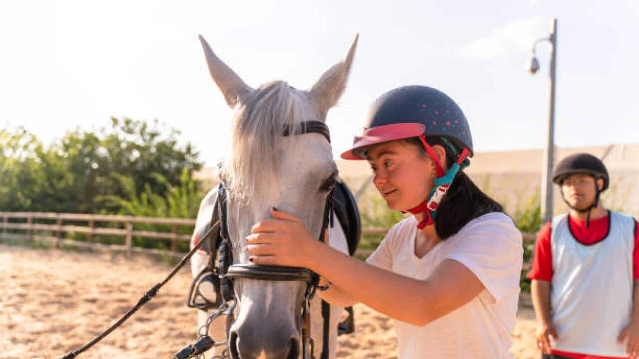Autistic girl and caressing a horse - Getty Images.