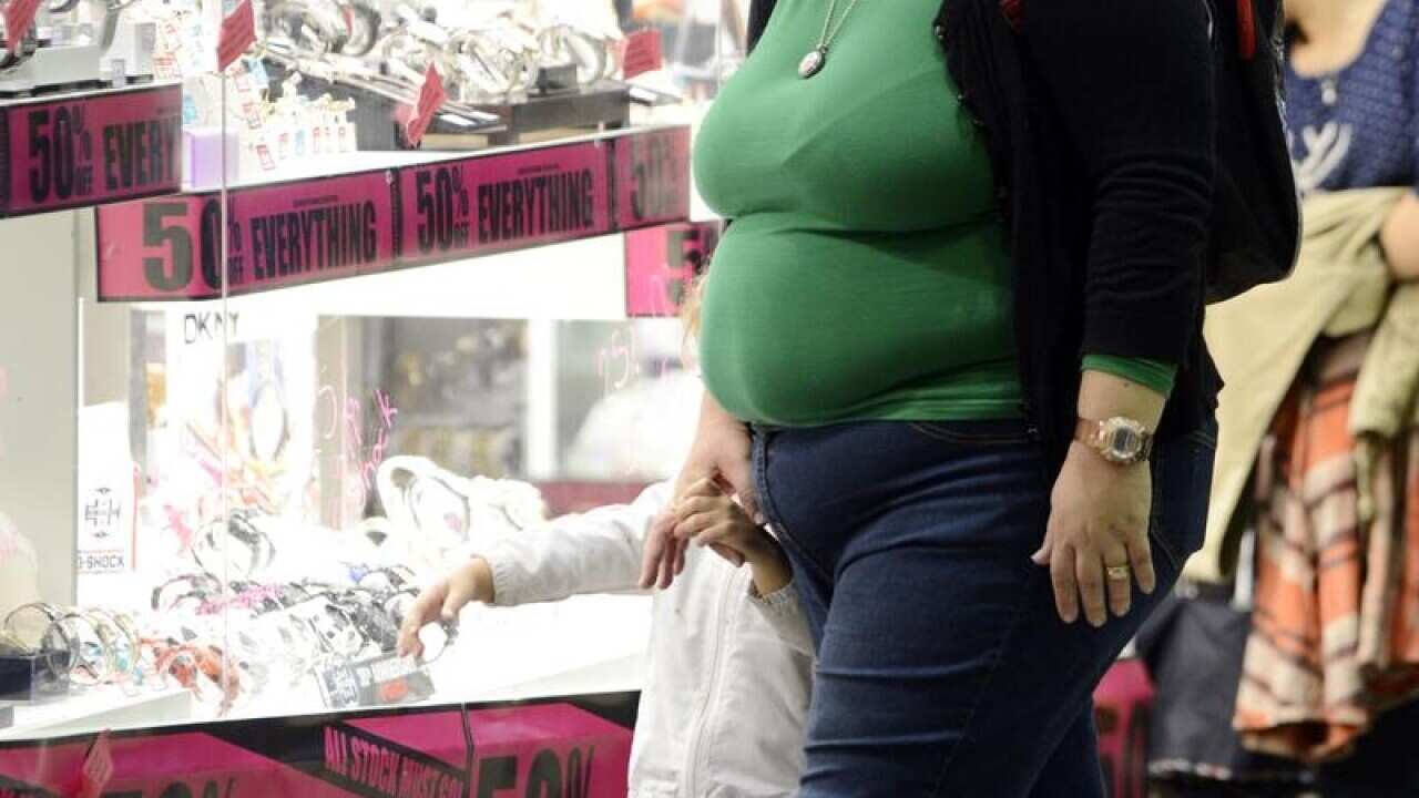 An overweight person window-shops at a mall