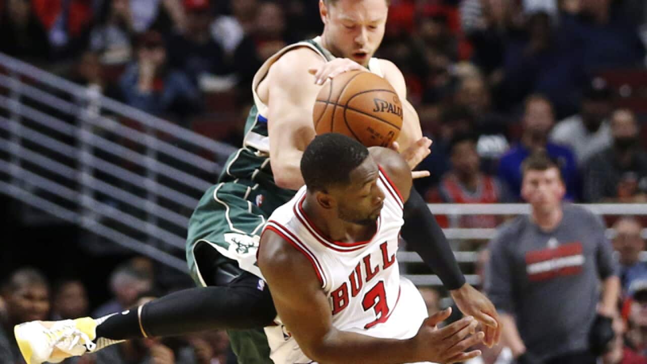 Bulls' Dwyane Wade (3) fouls Bucks' Matthew Dellavedova