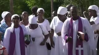 A group of African mourners in white gowns.