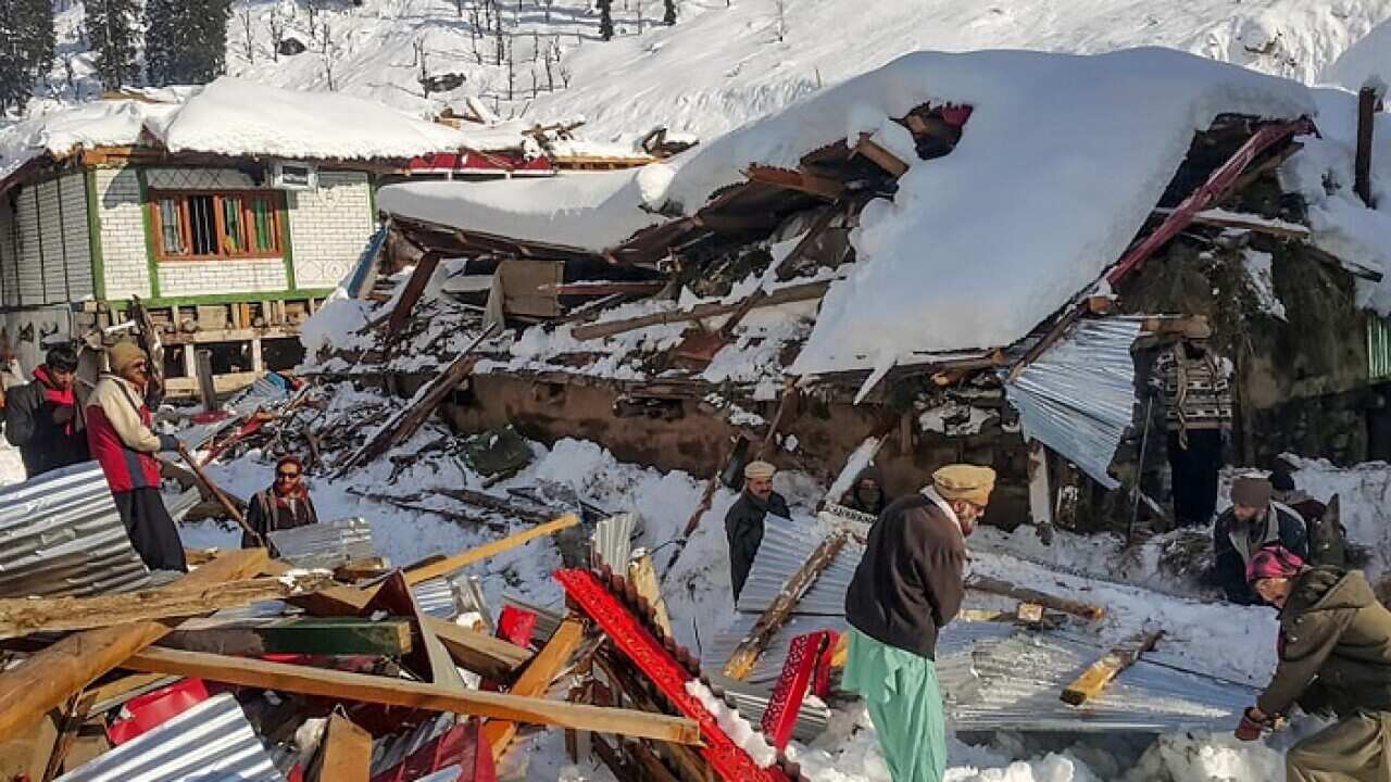 Local residents remove debris of a collapsed house in Neelum Valley, in Pakistan-administered Kashmir on January 14, 2020.