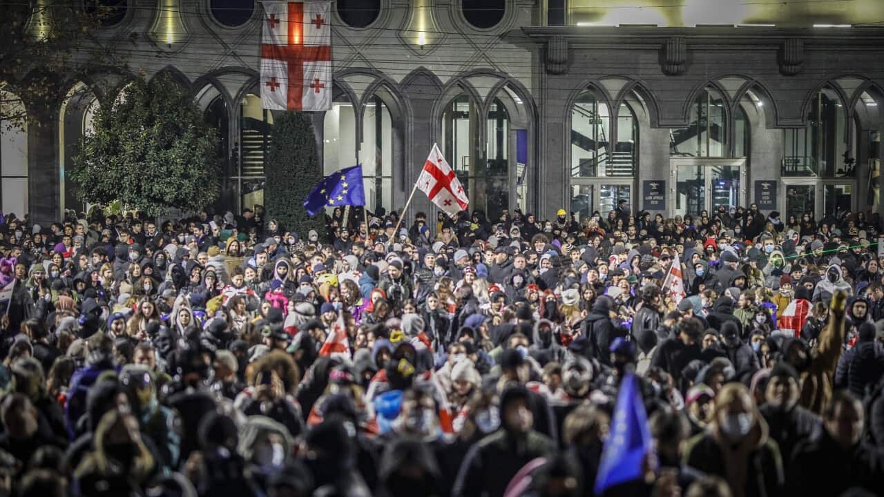 A large crowd of people protest in front of Parliament building in Tbilisi, Georgia