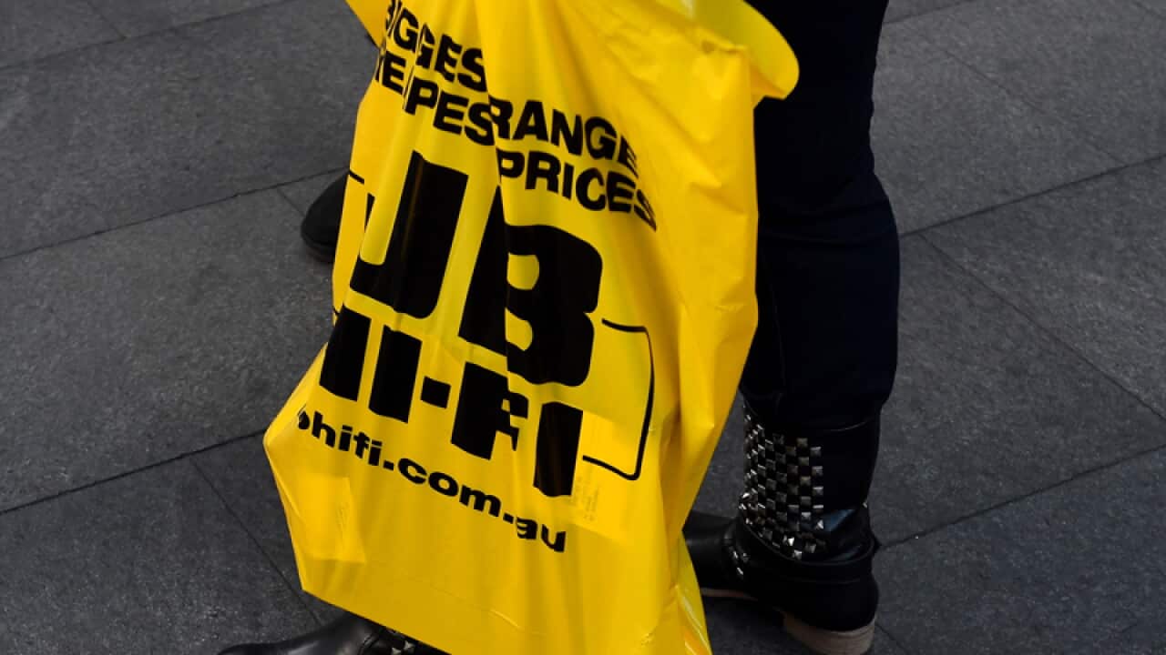 A shopper with a JB Hi-Fi bag
