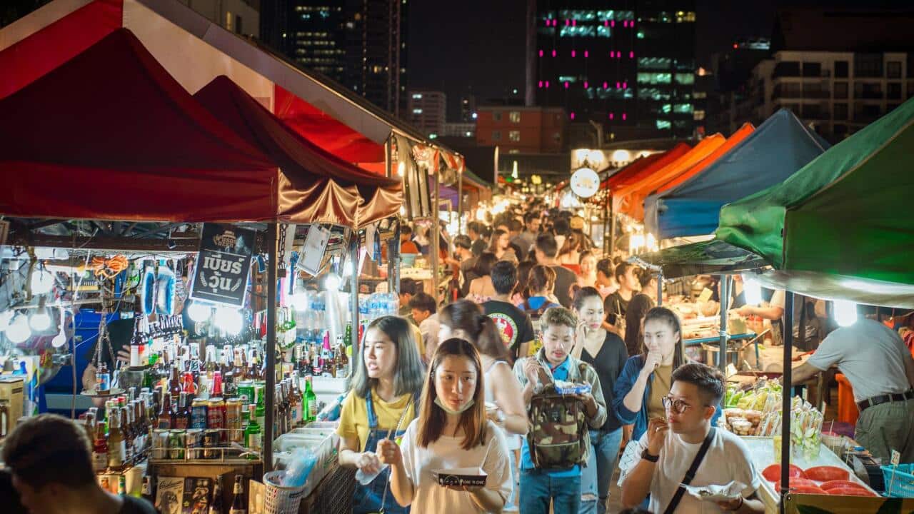 Young locals and tourists eat and wander around the streets of the Train Market in Ratchada.