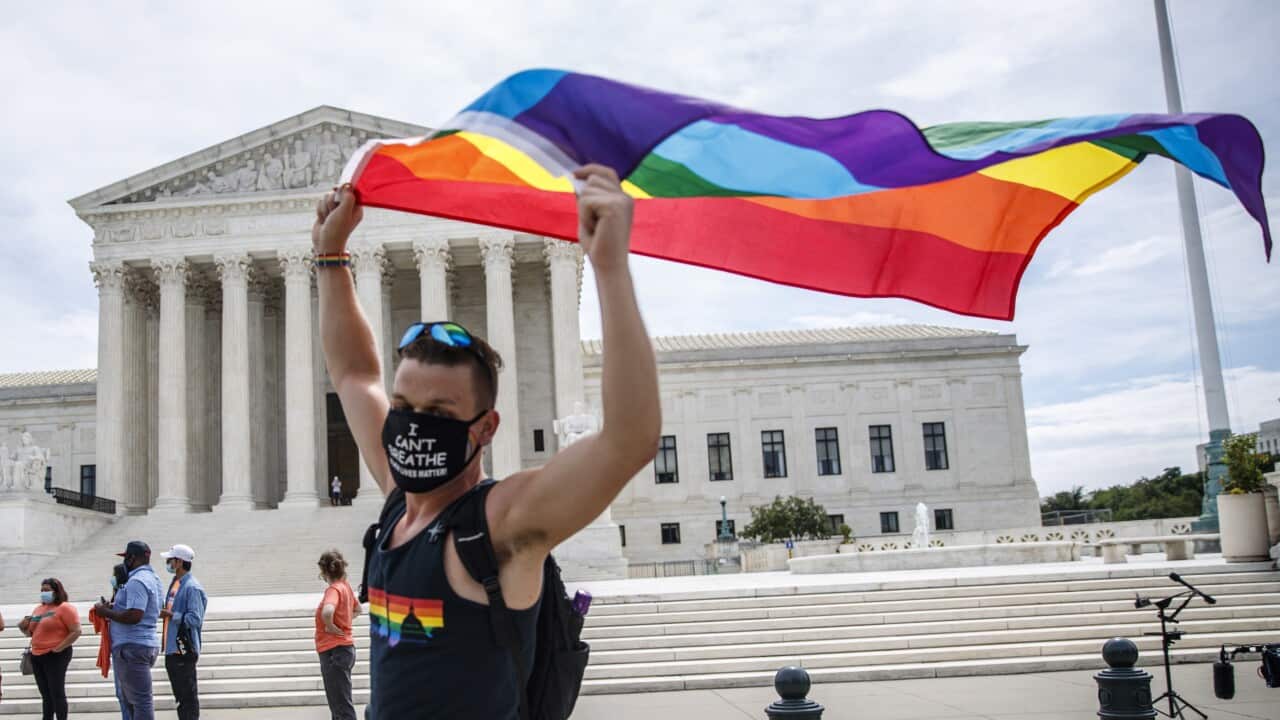 An LGBTQ supporter walks with a flag in front of the Supreme Court in Washington, DC, USA, 15 June 2020.