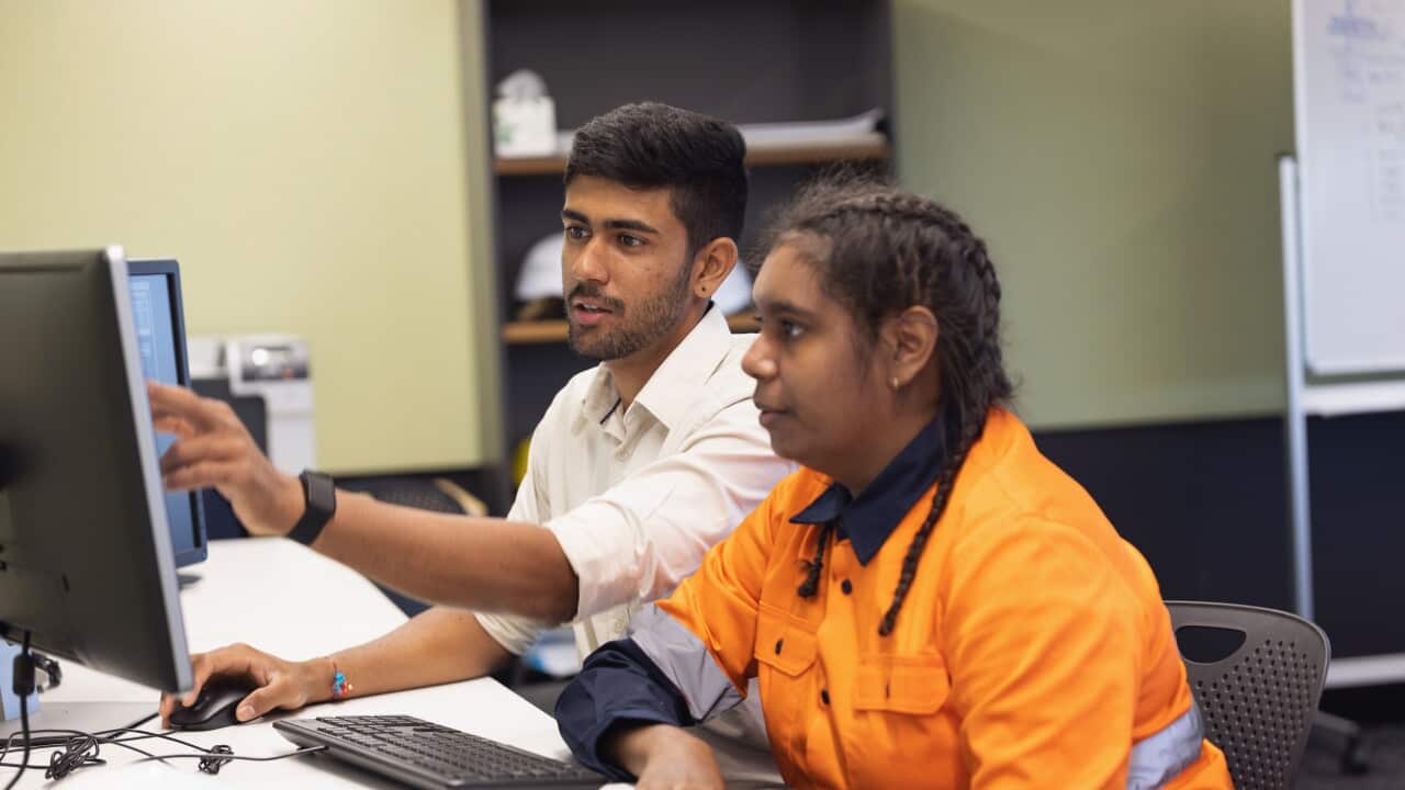 Engineer and Apprentice Working Together In Office