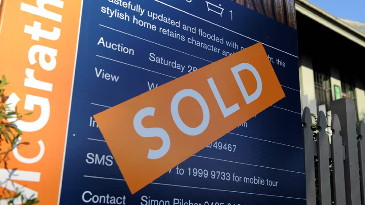 A house with a 'For Sale/Sold' sign in Sydney