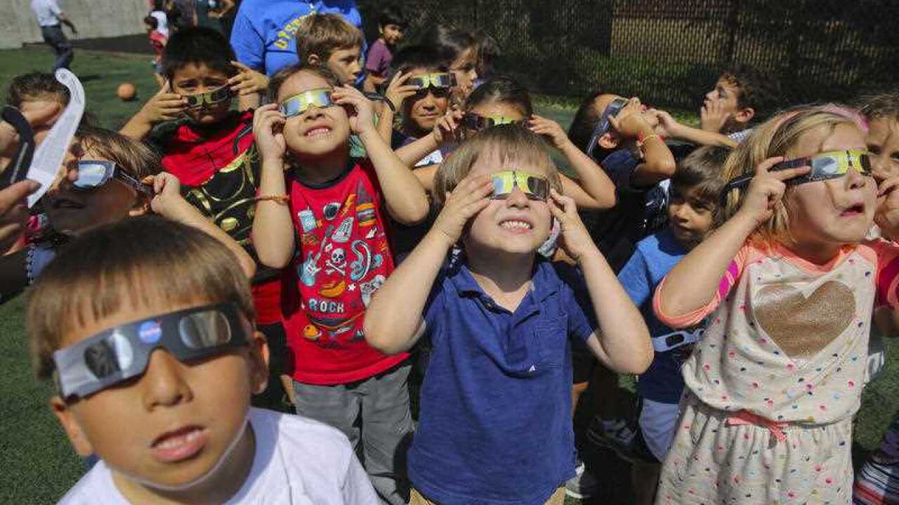 First grade students from Oyster-Adams Bilingual School in Washington, watch the eclipse as part of their first day of class activities