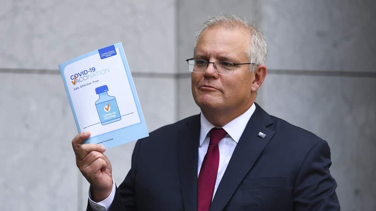 Australian Prime Minister Scott Morrison holds up a COVID19 vaccination leaflet as speaks to the media during a press conference at Parliament House in Canberra, Thursday, February 4, 2021.