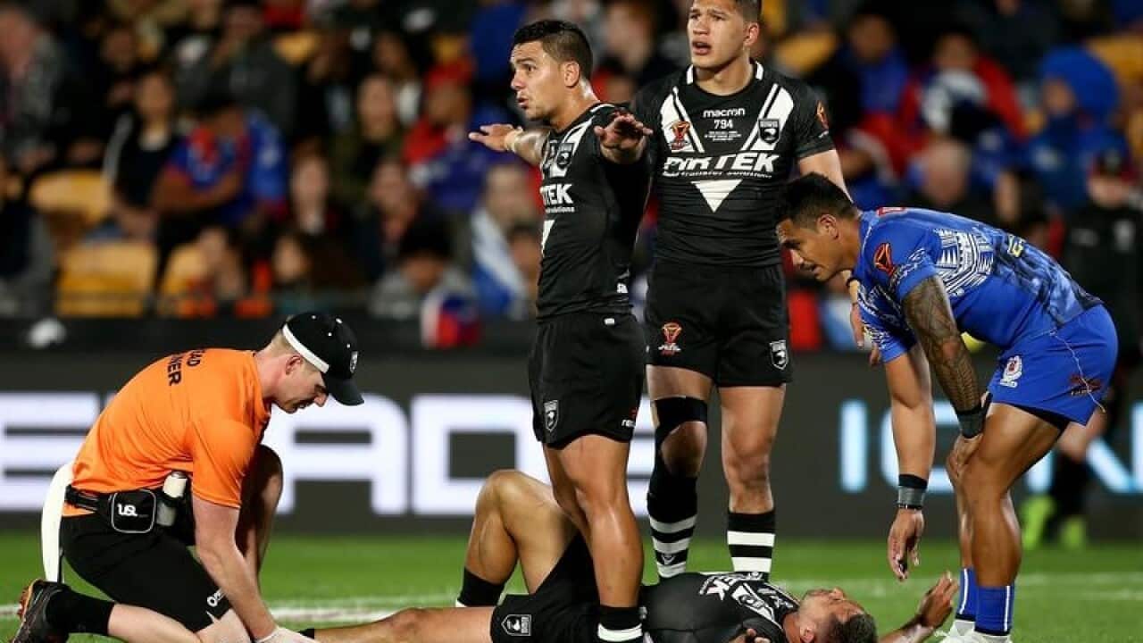 Kodi Nikorima, standing, indicates that Gerard Beale lies injured.