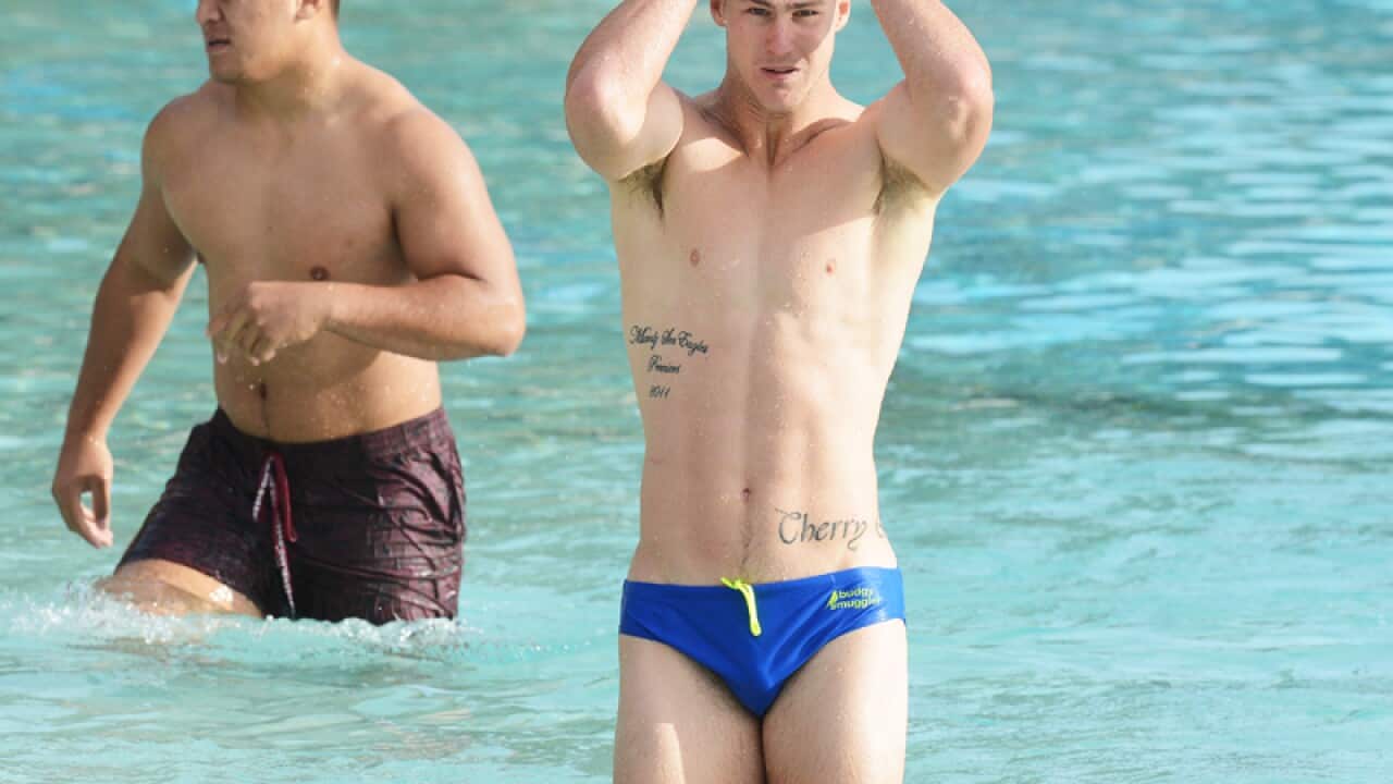Daly Cherry-Evans (centre) looks on during an early morning swim.