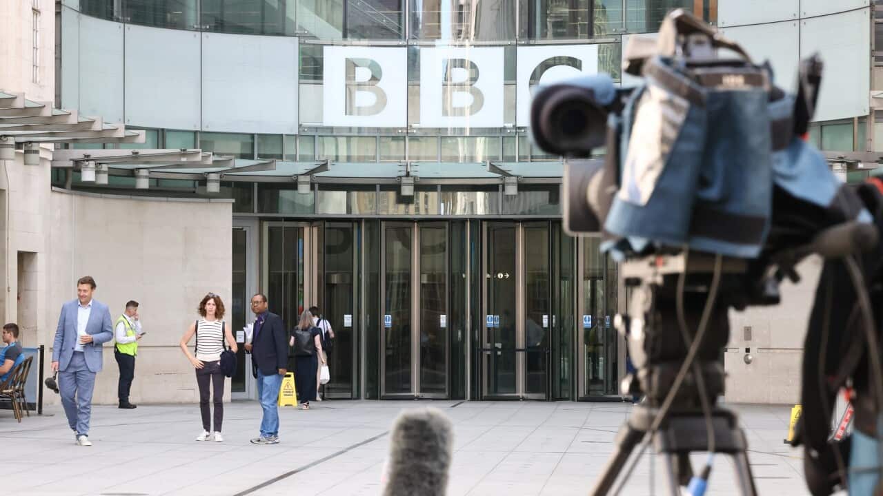 Members of the media gather at the entrance to BBC Broadcasting House in London
