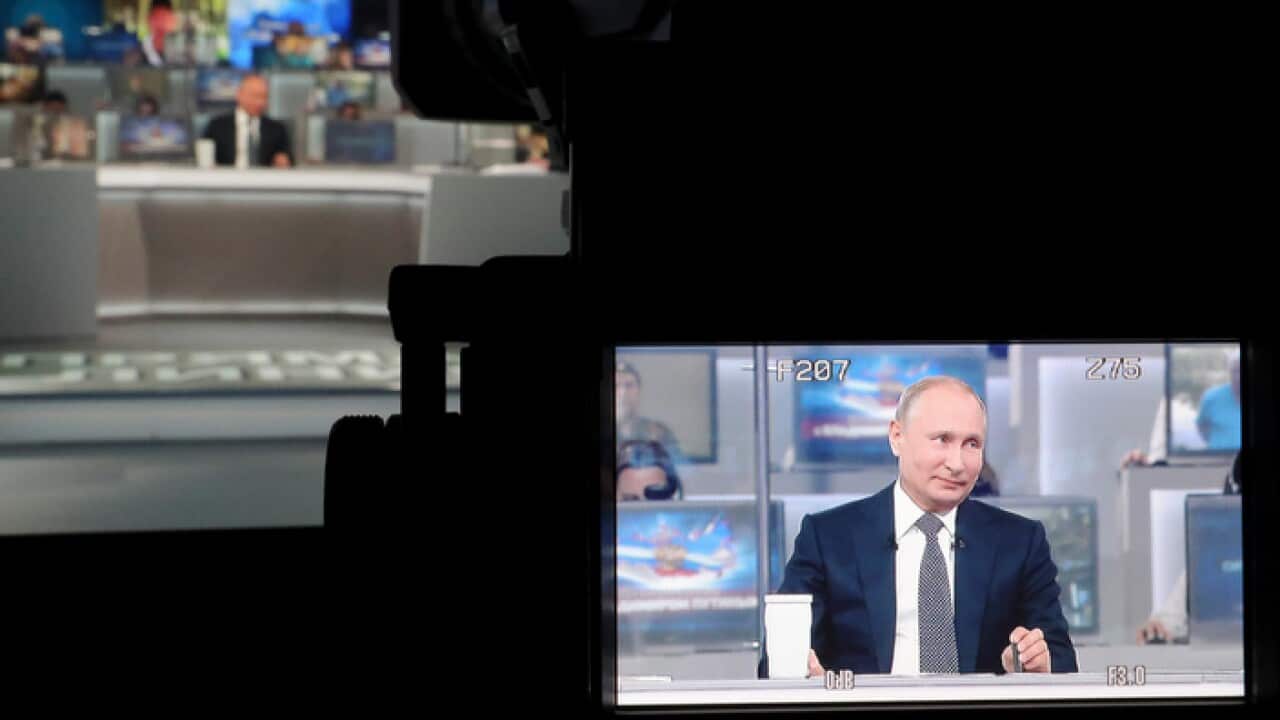Russian President Vladimir Putin is seen on the TV camera screen as he answers a question during his annual call-in show in Moscow