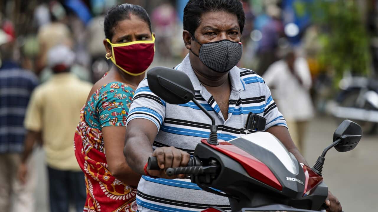 A couple wearing a face mask as a precaution against the coronavirus travel on a two wheeler in Kolkata, India.