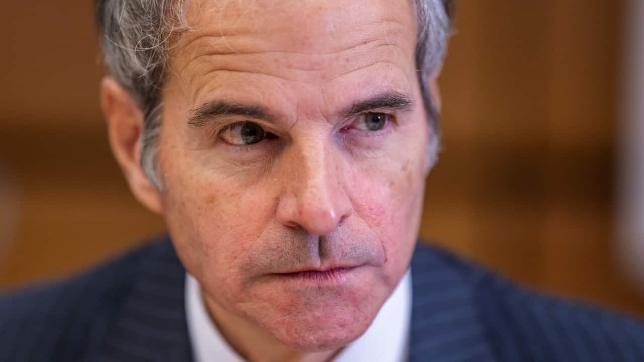 Rafael Grossi stares intently into the distance while seated