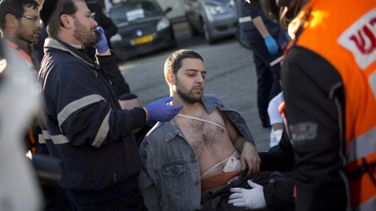 An injured man is treated at the scene of a stabbing in Tel Aviv