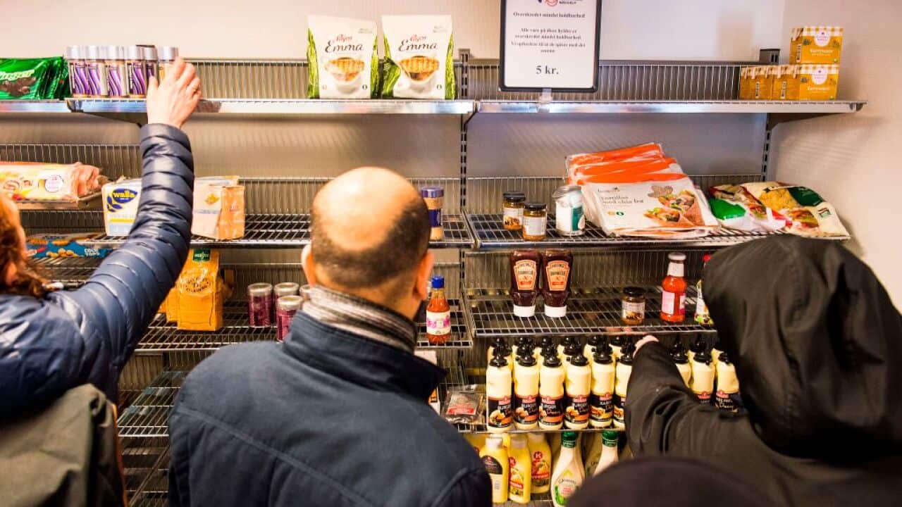 This picture from February 22, 2016 shows people shopping in the Wefood supermarket that sells food past its sell-by date at Amager in Copenhagen, Denmark.