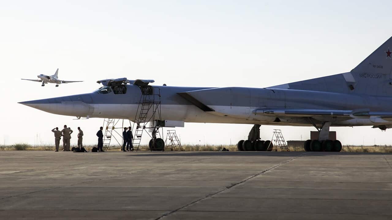 In this photo taken on Monday, Aug. 15, 2016, a Russian Tu-22M3 bomber stands on the tarmac while another plane lands at an air base near Hamedan, Iran.