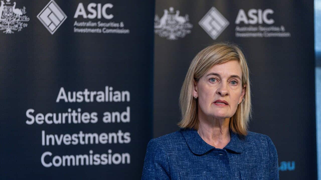 A woman speaking into several lectern microphones at an ASIC press conference.