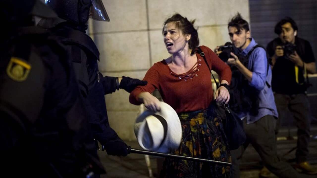 A police officer struggles with a demonstrator in Madrid