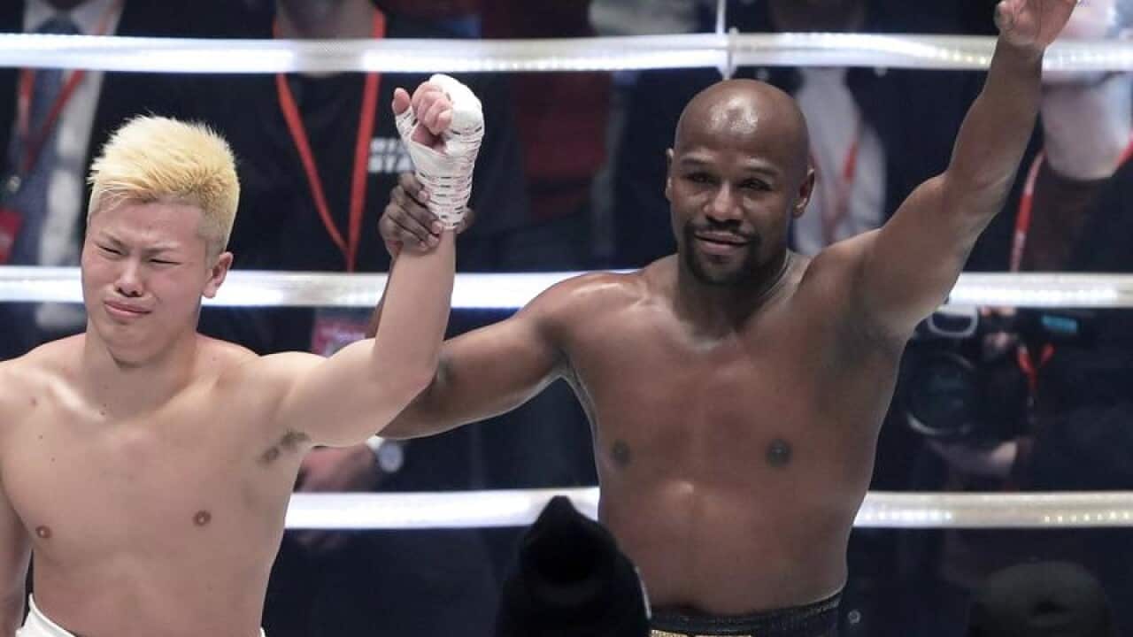 Former US boxer Floyd Mayweather (R)