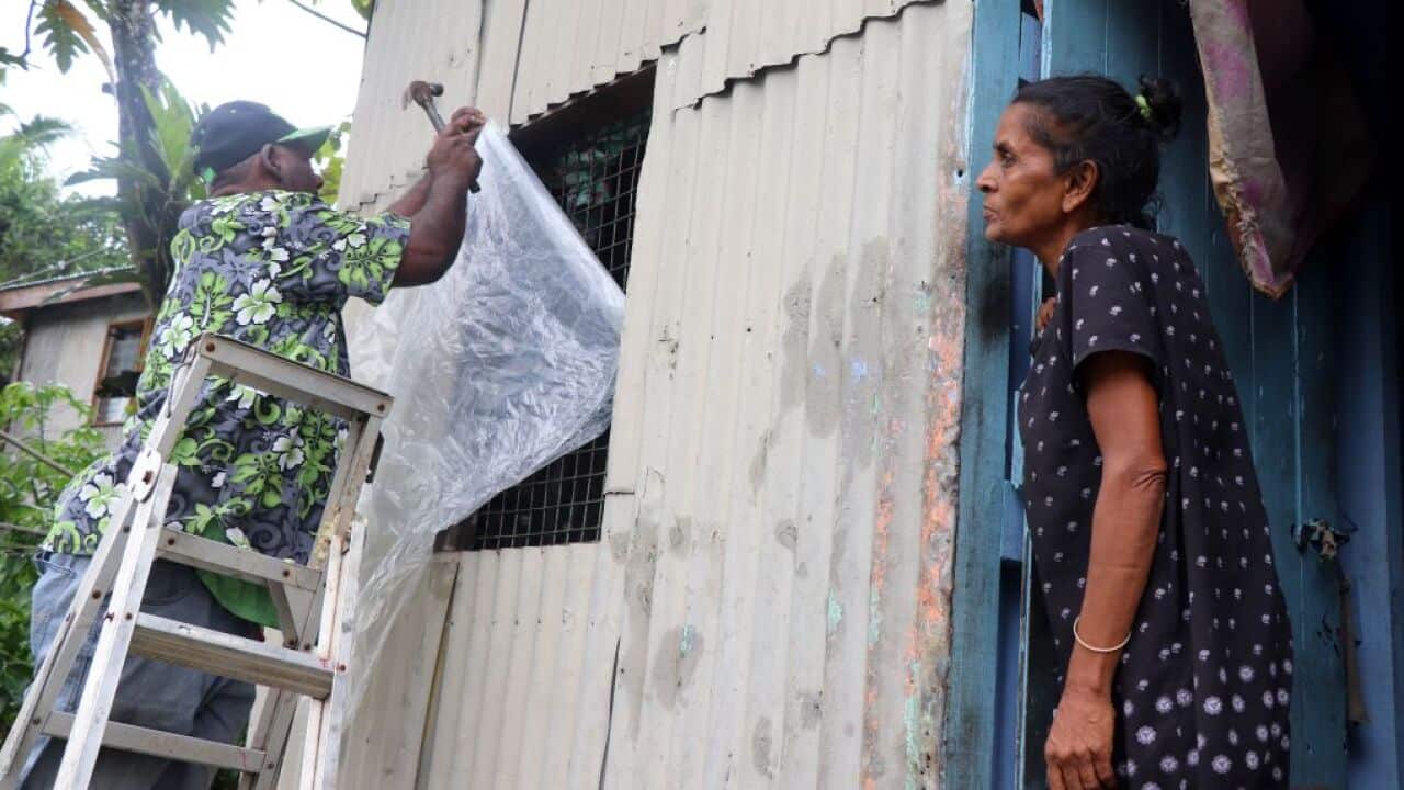 A resident secures his house by placing plastic sheets on the windows ahead of the arrival of super Cyclone Yasa in Fiji's capital city of Suva on December 16, 2020. (Photo by Lice MOVONO / AFP) (Photo by LICE MOVONO/AFP via Getty Images)
