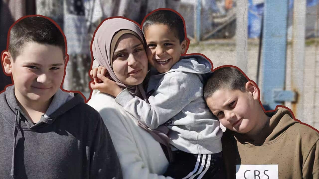 A woman wearing a hijab is holding a young boy in a grey hoodie with his hands wrapped around her neck. Two pre-teen boys are standing on each side of her. They are outlined in burgundy, and the background behind them is slightly blurred.