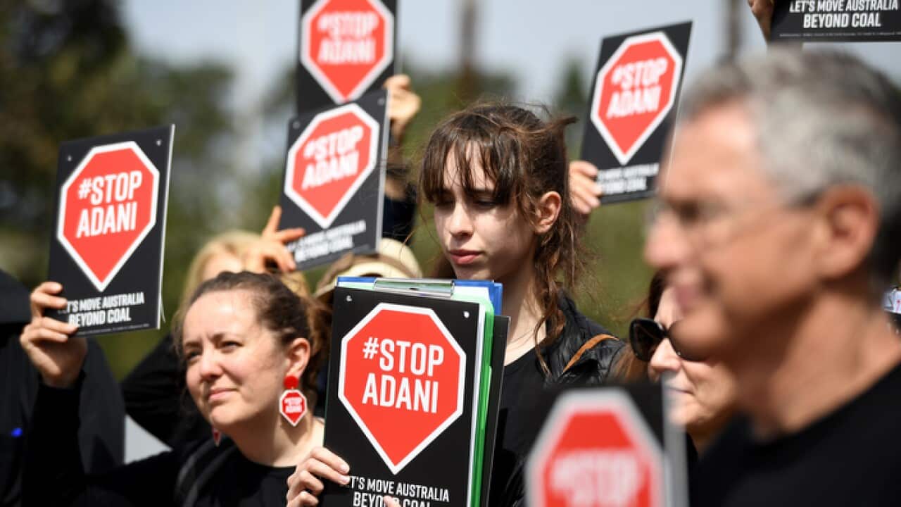 Anti-Adani supporters holding placards