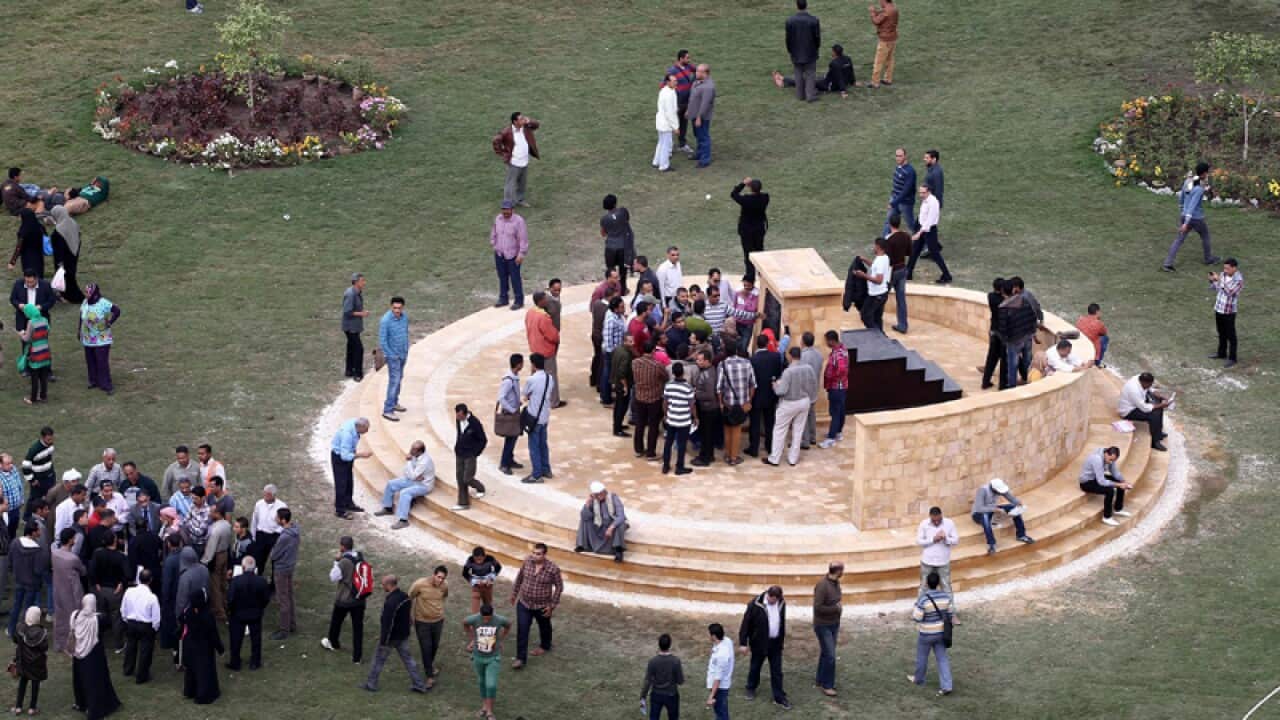Egyptians gather around a memorial
