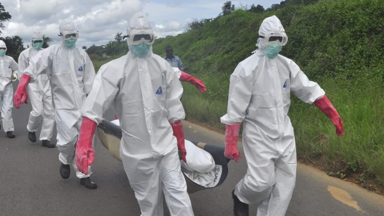 Burial team in protective gear carry a body