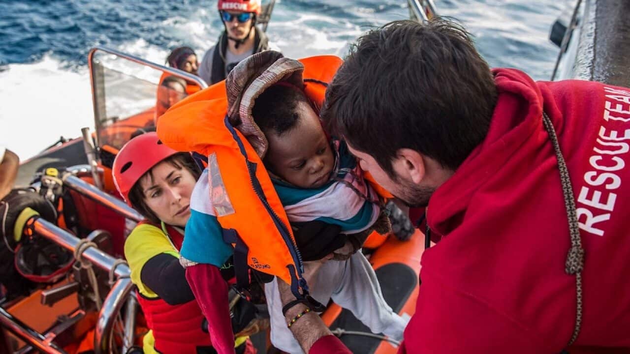 A baby is loaded into the rescue vessel of the Spanish NGO Proactiva Open Arms on 21 December, 2018.