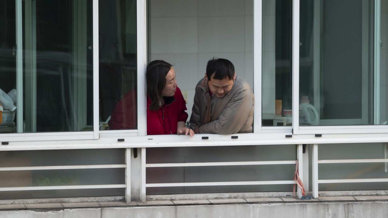 Citizens look out from a window of a high-rise building in Shanghai whilst under lockdown.